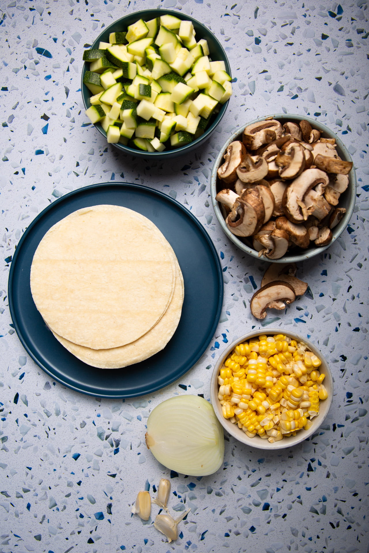 Slice of vegan enchilada casserole on a plate topped with sliced avocado and fresh cilantro