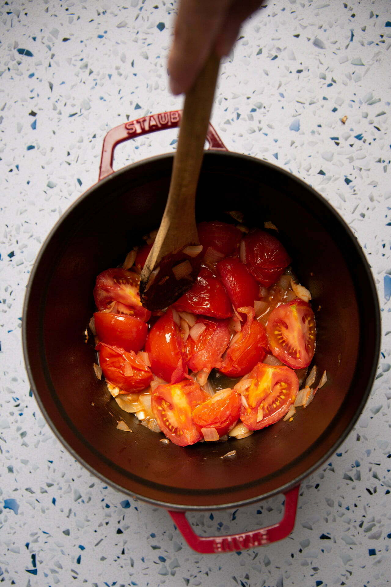 Layering corn tortillas and guajillo sauce in a baking dish for vegan enchilada casserole