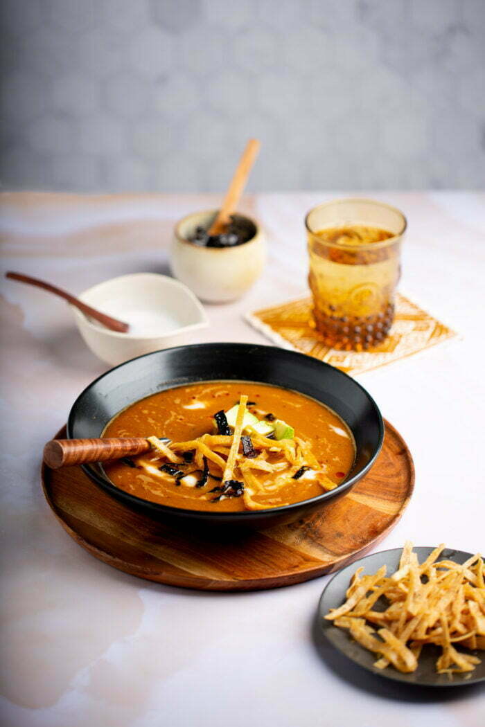 Sopa tarasca vegana servida en un tazón negro