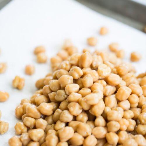 Raw chickpeas on a baking sheet.