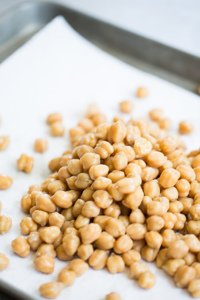Raw chickpeas on a baking sheet.