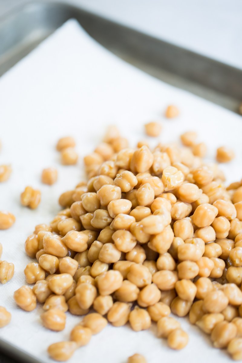 Raw chickpeas on a baking sheet.