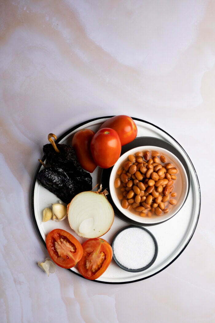 pinto beans, roma tomatoes, halved onion, arlic, salt and dried chile ancho to make the soup.