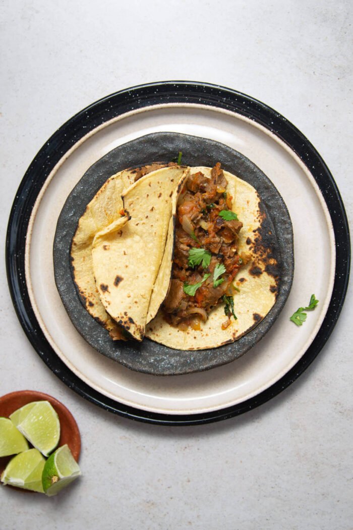 bistec a la mexicana tacos over a stack of three plates