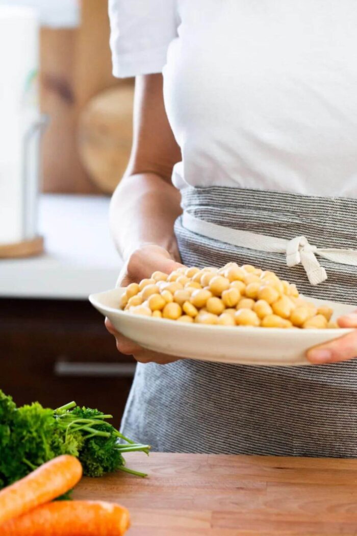 women handing a dish with chickpeas