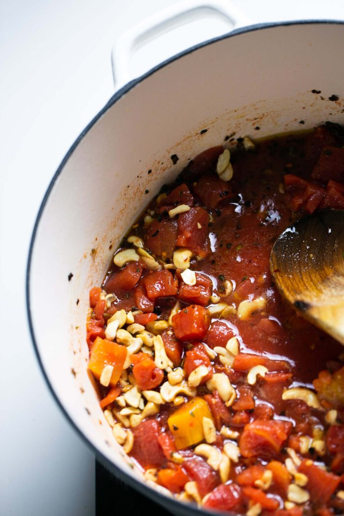 Tomatoes, cashews and aregano in a dutch oven