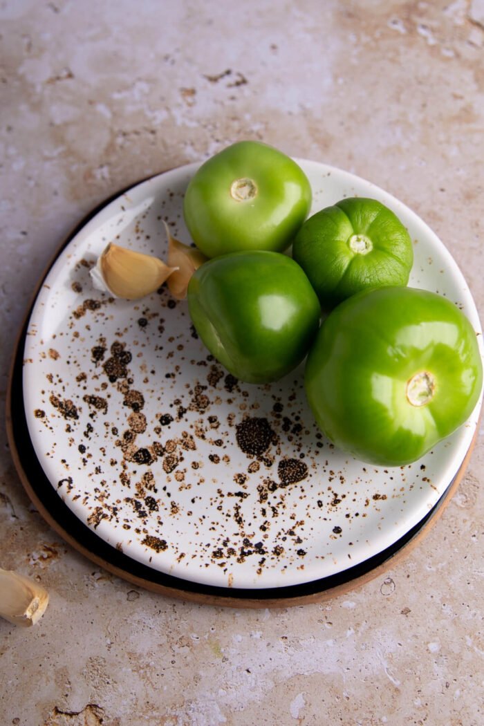 Tomatillos and garlic on a saucer