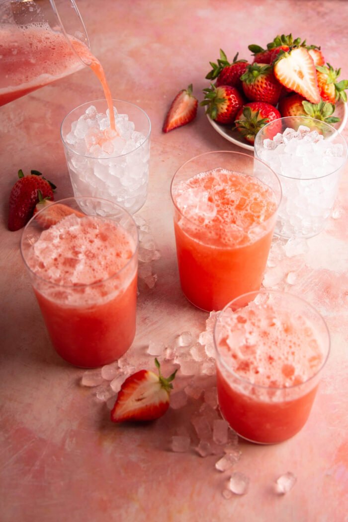 serving agua de fresa in filled with ice glasses