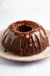 A decadent chocolate bundt cake is sitting on a plate.