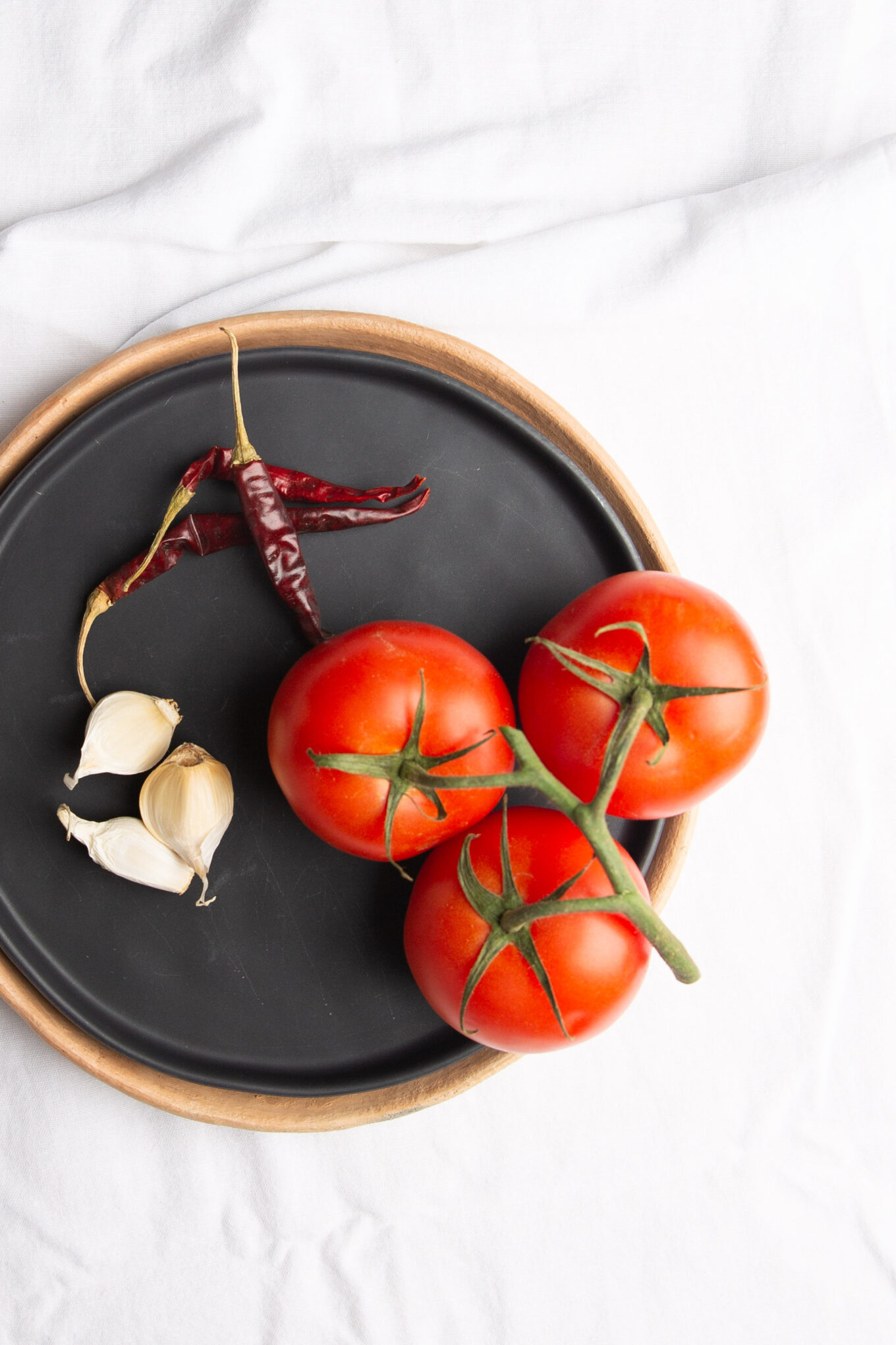 A black dish with tomatoes, garlic and chiles - Estrujadas Veracruzanas.