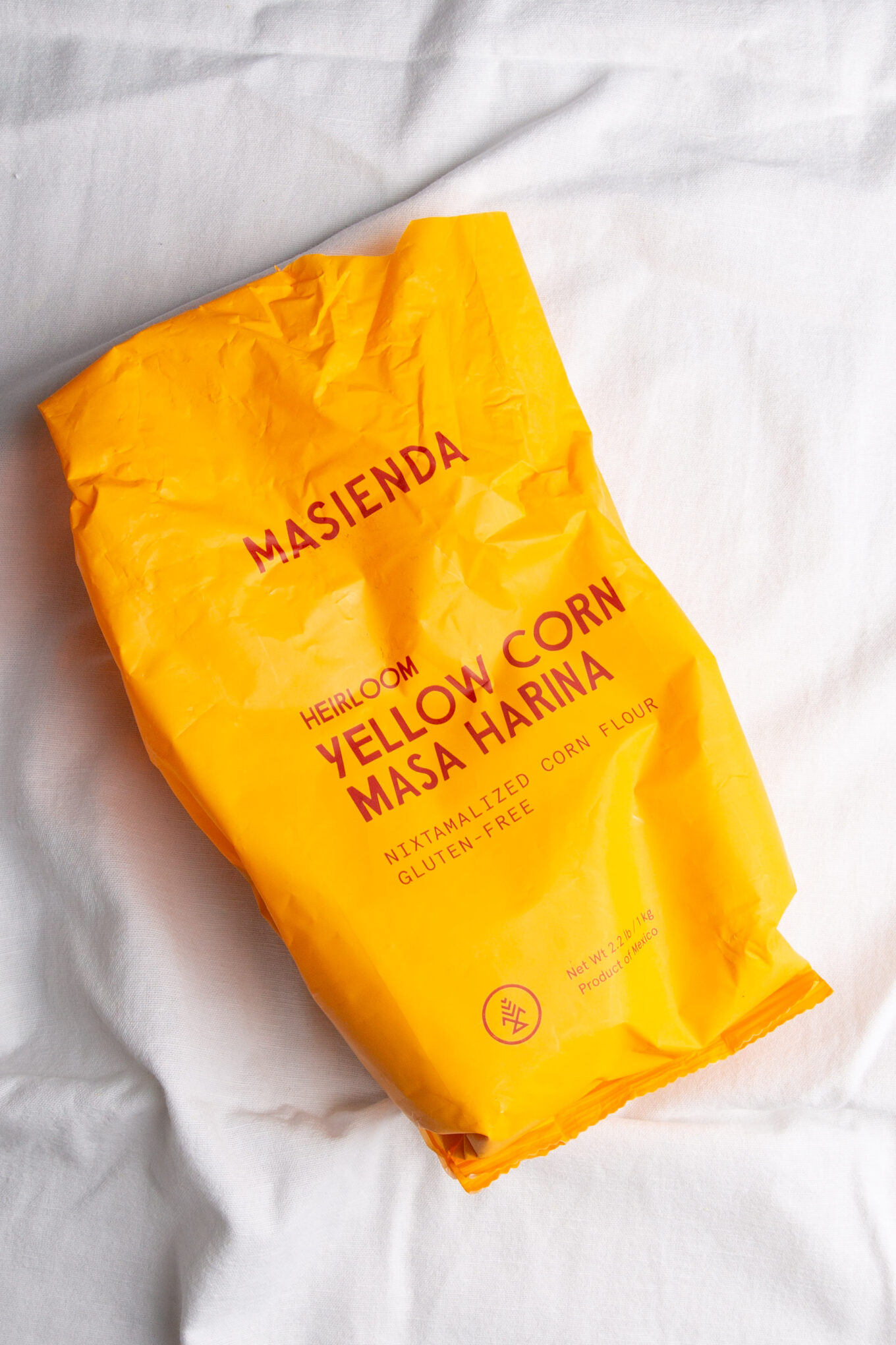 A bag of Estrujadas Veracruzanas corn mask sitting on a bed.