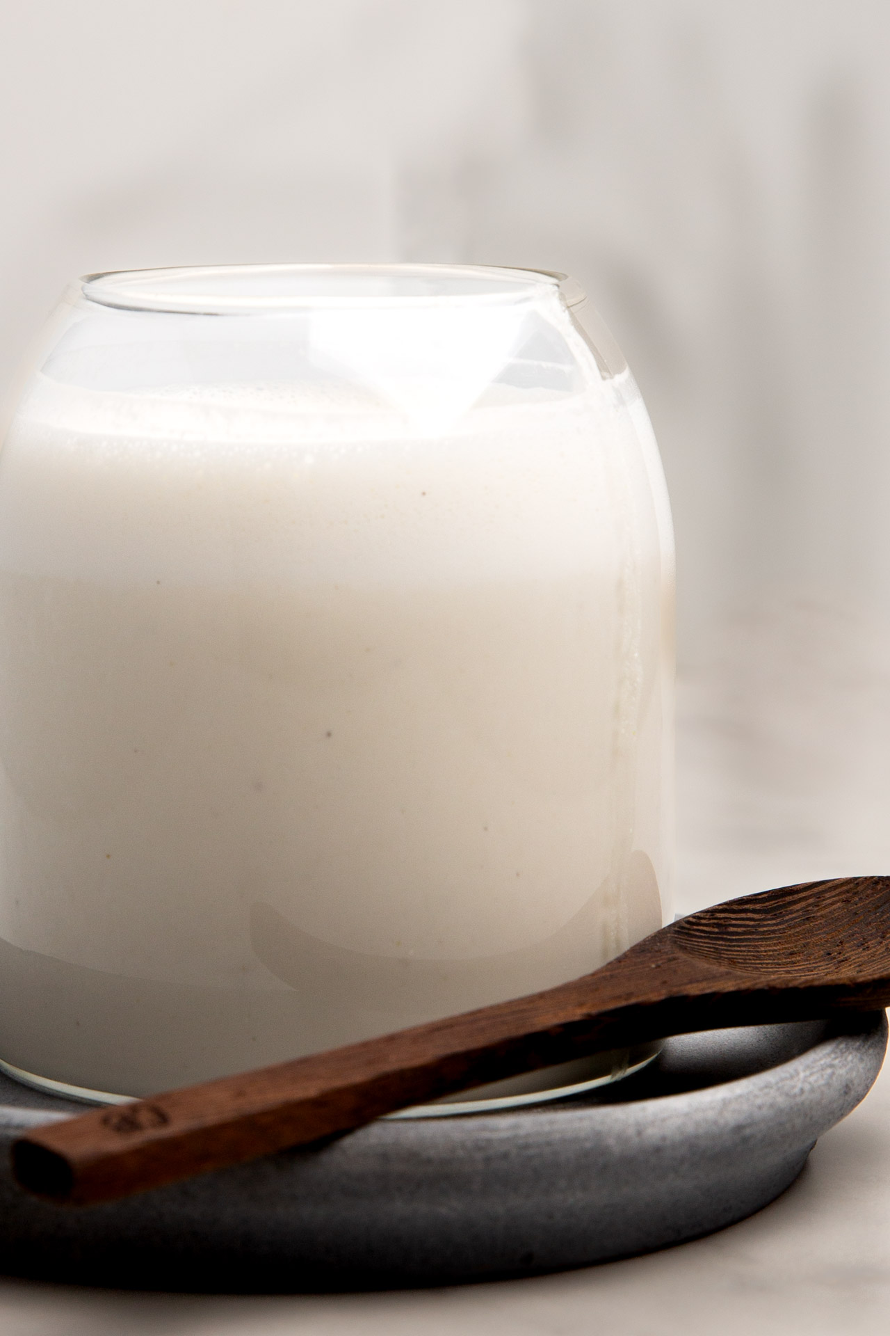 A glass of milk on a plate.