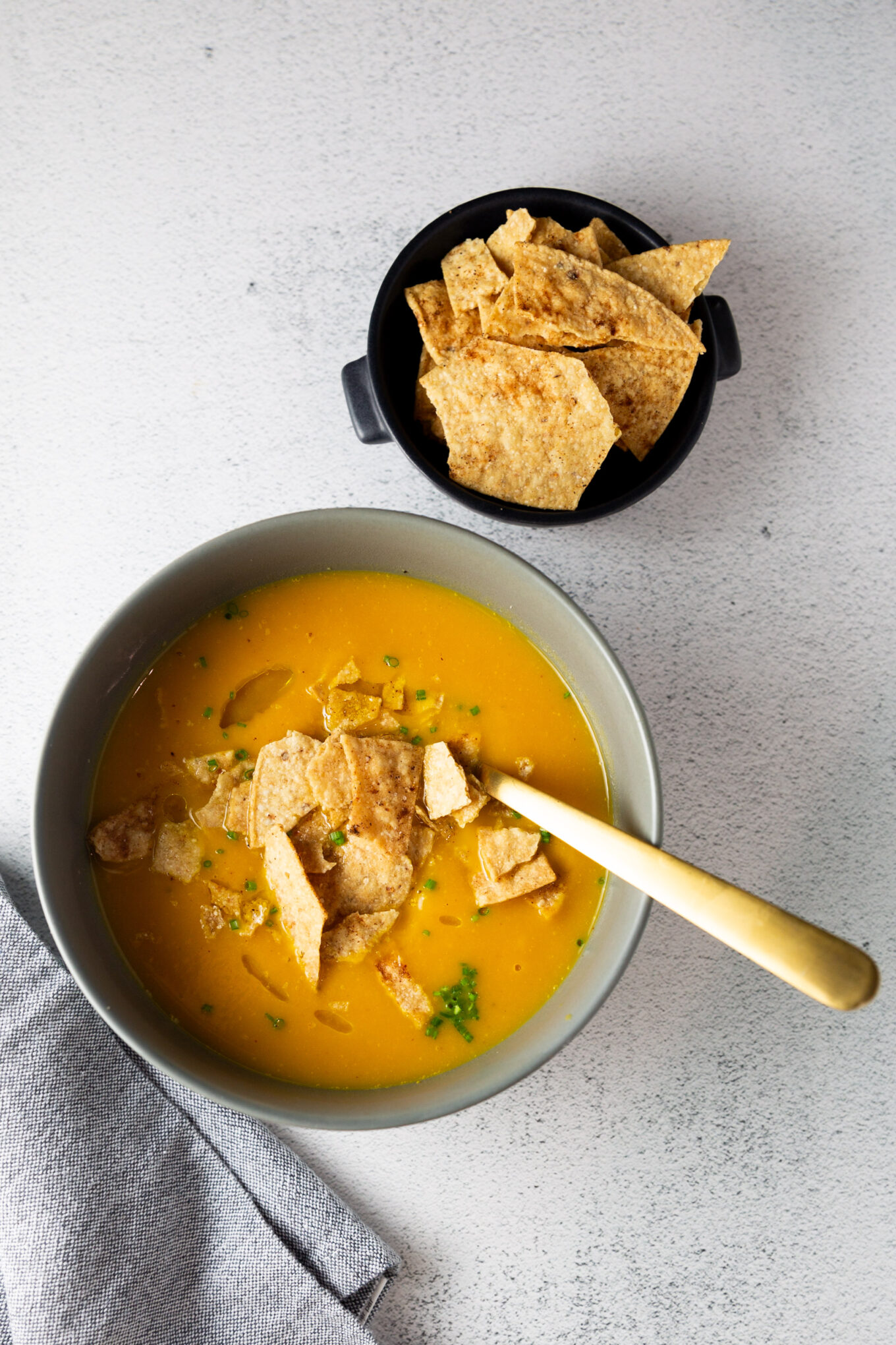 An easy recipe for Butternut Squash Soup with tortilla chips next to it.