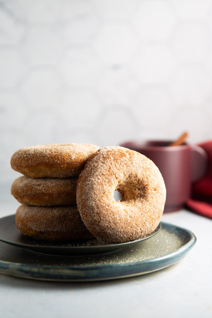 A stack of vegan apple cider donuts on a plate.