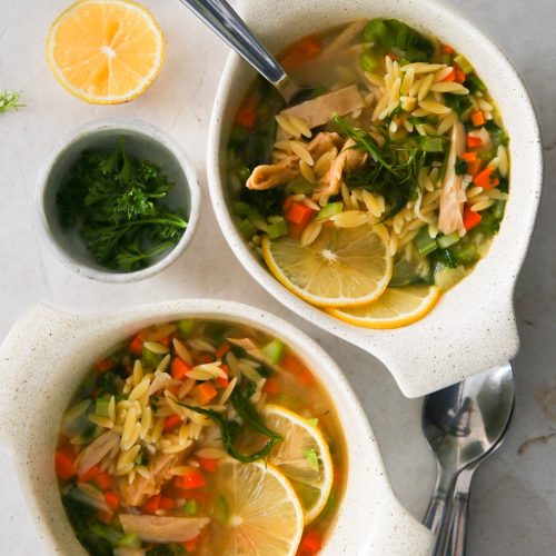 Two bowls of vegan noodle soup with lemon.