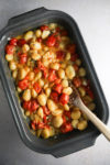 A baking dish filled with tomatoes and beans.