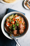 A bowl of Vegan soup with meatballs and vegetables.