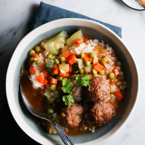 A bowl of Vegan soup with meatballs and vegetables.
