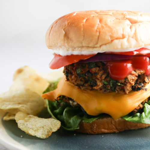 A Southwest-inspired burger on a plate with fries.