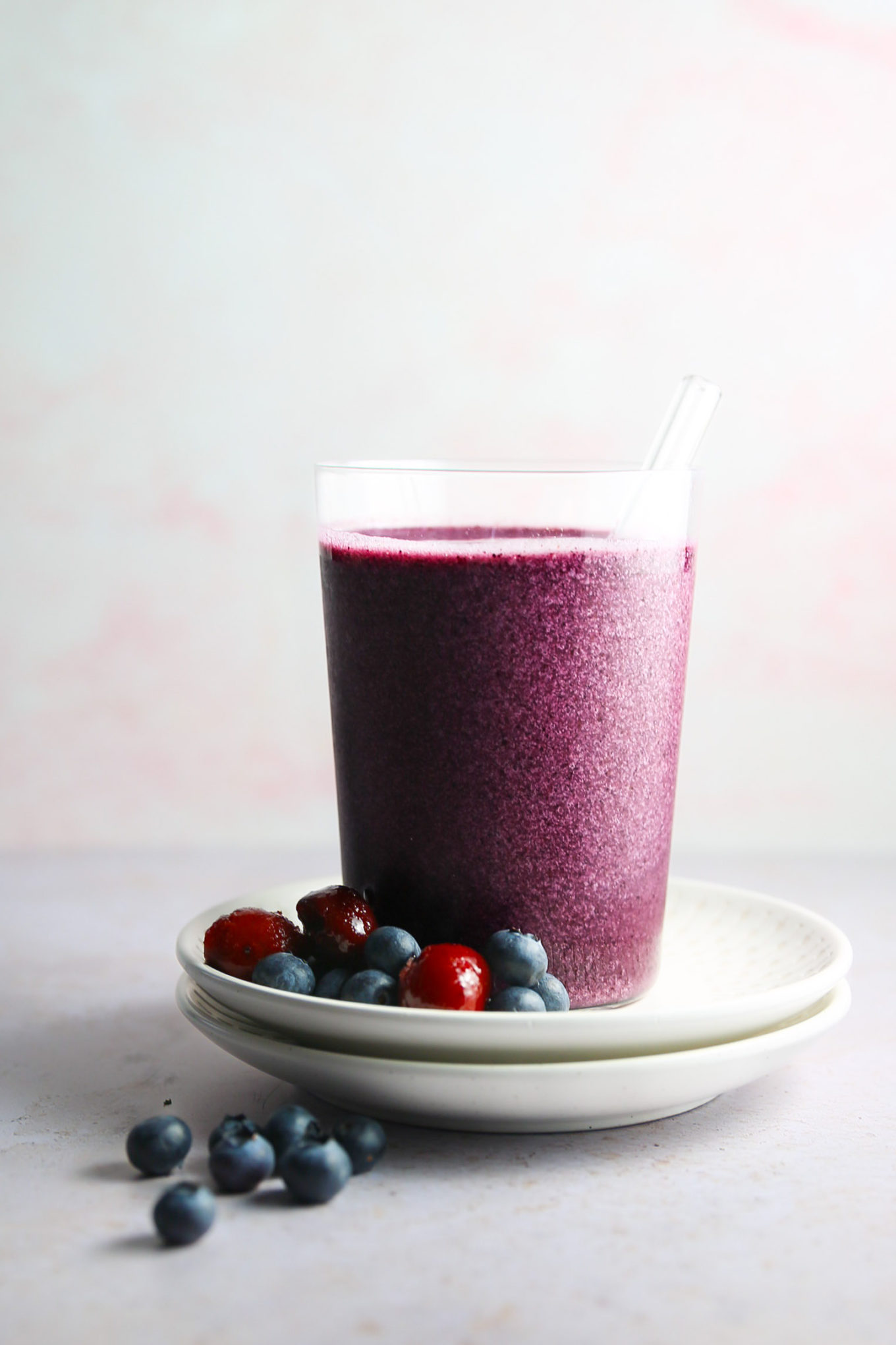 A blueberry smoothie with blackberries on a plate.