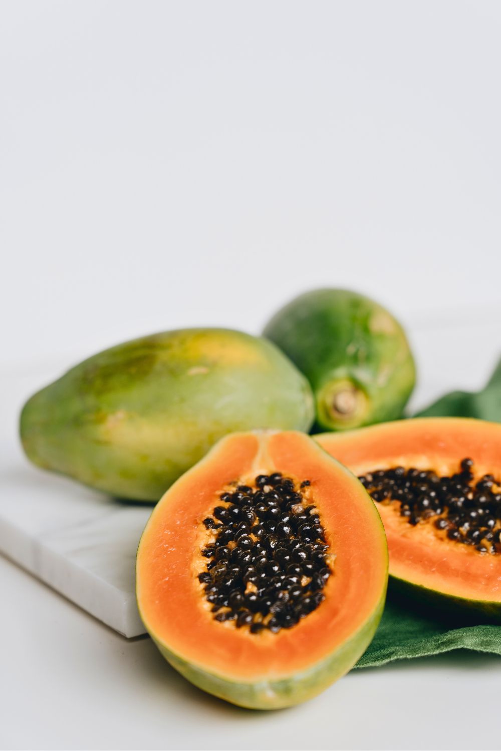 Auto Draft: Papaya on a white plate with leaves.