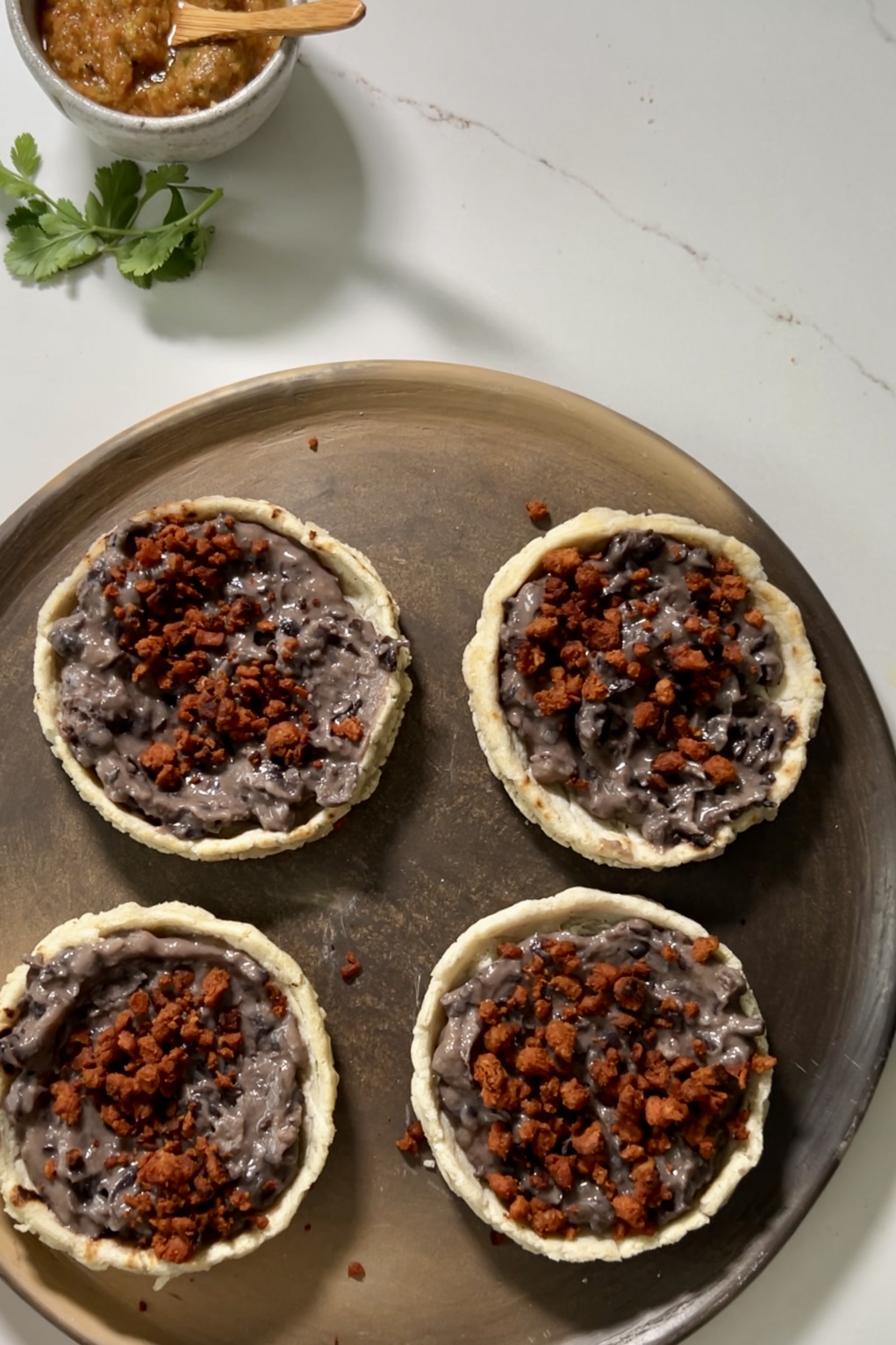 four sopes with refried beans and chorizo