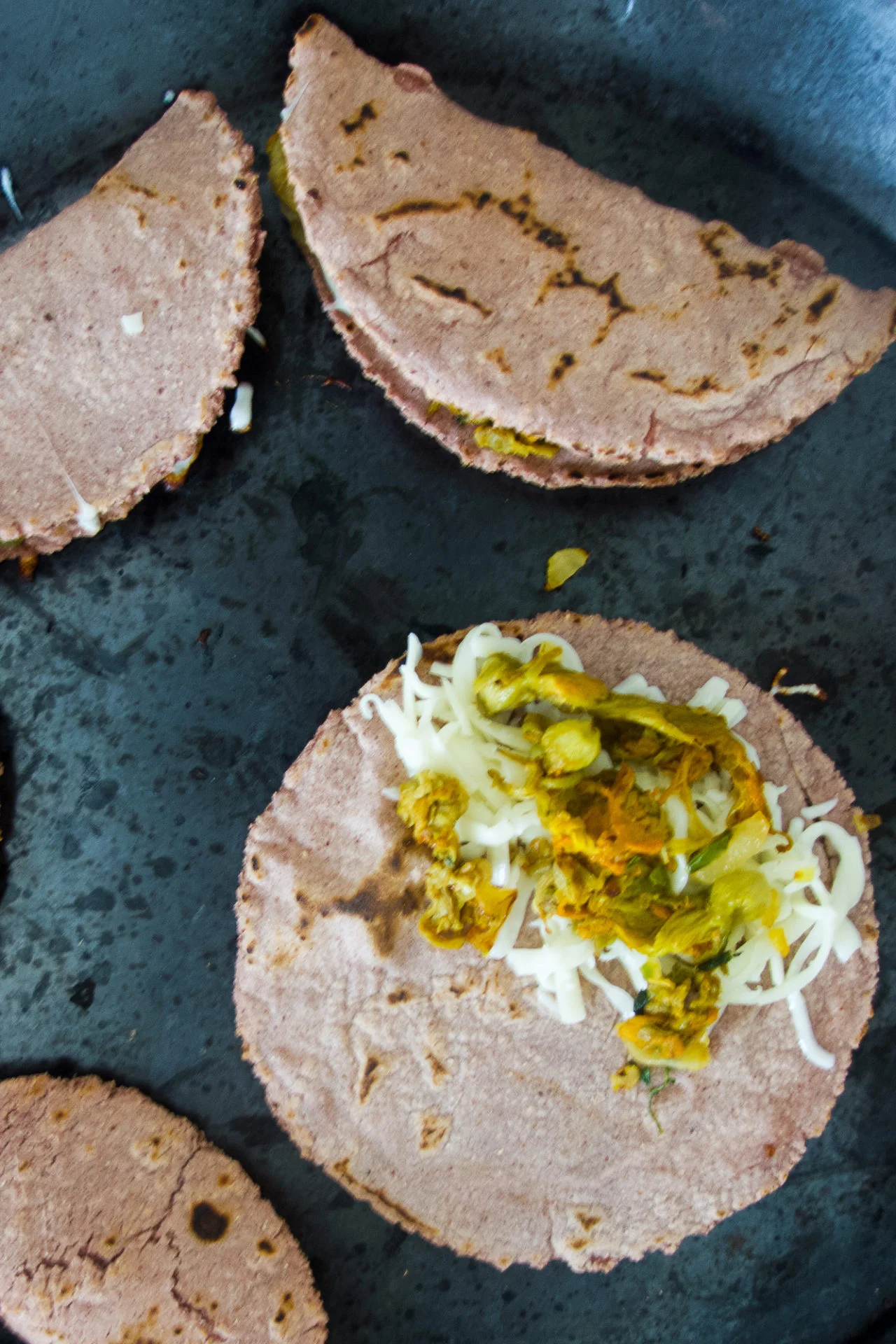 A group of tortillas with cheese and vegetables, these are classic Squash Blossom Quesadillas—an authentic example of Quesadillas de Flor de Calabaza and a delicious choice for fans of squash blossom recipes.