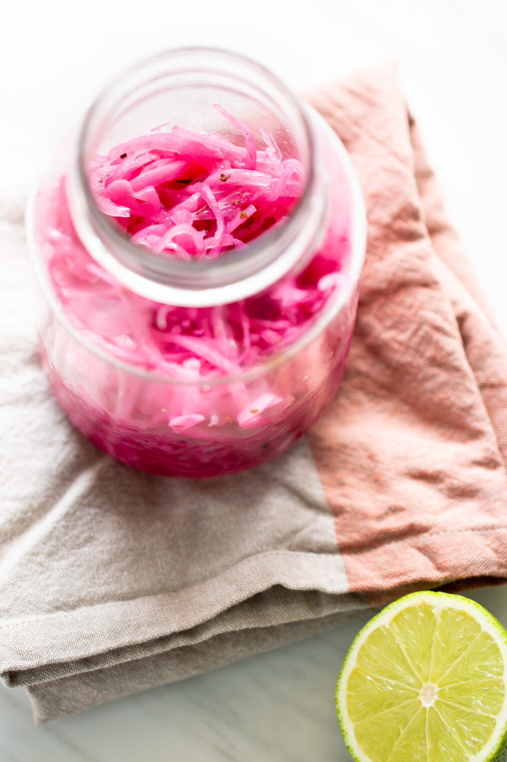 Frasco de vidrio con cebollas moradas encurtidas en vinagre, listas para servir